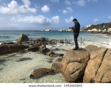 Man taking a picture of the beach view with camera