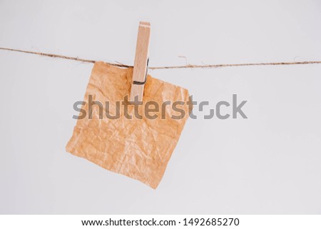 Brown stickers on clothesline with wooden clothespin isolated on white background. Place for your text