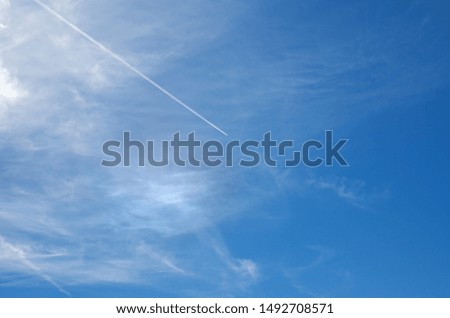 Blue sky with plane trace and white clouds