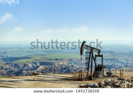 View of the pumpjack or piston pump in the oil well (oil field). Modern pumpjacks are powered by a prime mover. This is commonly an electric motor.