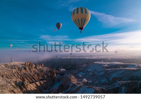Hot air ballons flying over Cappadocia National Park Göreme Turkey, fogyy air Royalty-Free Stock Photo #1492739057