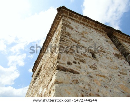 
View of the beautiful stone tower of a medieval fortress lit by the sun					