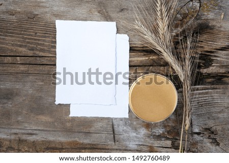 Blank greeting card. Vintage wood background. Flat lay, top view. Wedding invitation cards papers, rye laying on table. Mockup.