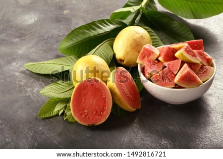 Healthy breakfast table view- nutritious and delicious vegan diet - organic pink guava fruit salad bowl on a rustic wooden background,
