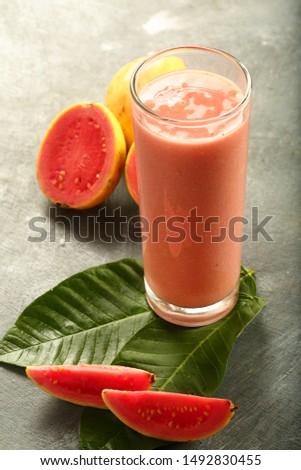 Healthy vegan diet drinks- glass of homemade delicious organic pink guava juice smoothie.