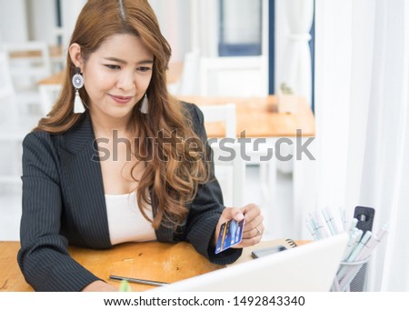 Beautiful businesswoman Thai people are checking credit card limits for online shopping.