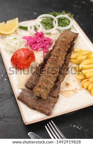 Arabian and Iranian kabab and salad on white  Plate on black table