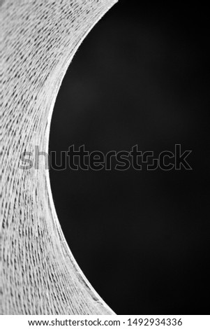 Abstract monochrome detail shot of a modern design cat cave. Half a circle with black space for text on the right. 