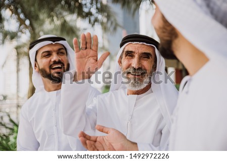 Businessmen in Dubai speaking about business. Local people with traditional clothes Royalty-Free Stock Photo #1492972226