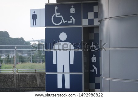 Men's restroom with signs for handicapped persons. Handicap facility