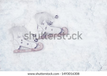 Merry Christmas and Happy New Year greeting card with wooden skates on snow background with copy space. Flat lay. Top View. 