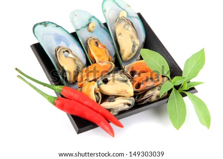 The picture Mussel on black dish and Vegetables placed beside.