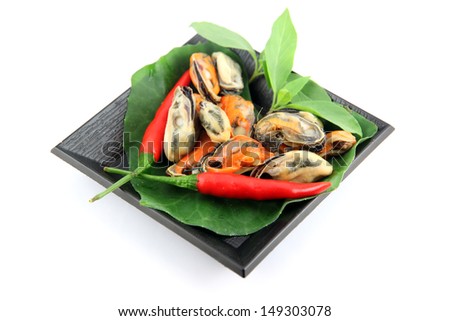The picture Mussel on black dish and Vegetables placed beside.