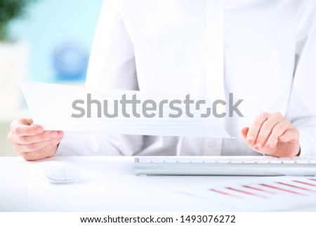 Female hands typing on computer keyboard and working with diagrams