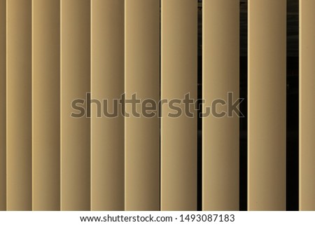 Beige or golden 3d stripes on black background. shutters like pattern.