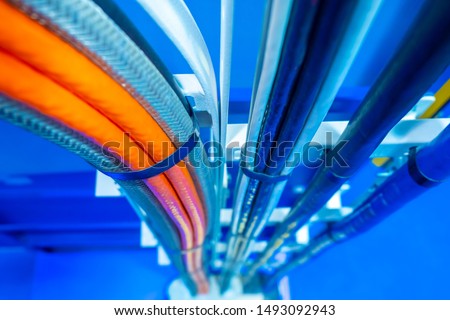 Production wiring. Electrical wiring in technical rooms. Electric wires are fastened by a plastic coupler. Cable wiring. Network engineering. Orange and deep blue electric wires.Work as an electrician Royalty-Free Stock Photo #1493092943