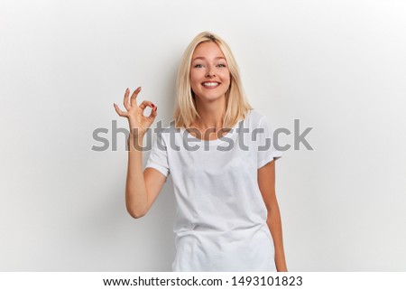 Portrait of a pretty positive smiling woman showing okay sign and over white background, close up portrait, everything is ok, allright. body language , agreement