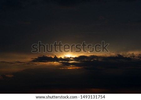 Sunset on the background of dark evening clouds, landscape in the countryside. Fall season. Natural Background.