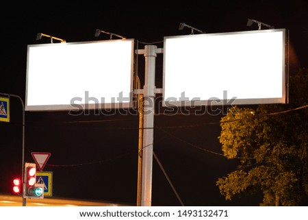 A mockup of a billboard at night near. two fields for advertising with a white field