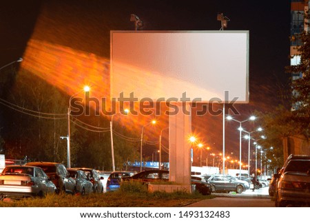 A mockup of a billboard with a white field for advertising. at night in the city lantern light rays of light effect