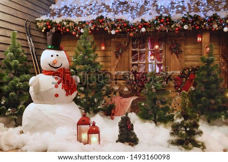 New Year's photo zone with a snowman at the house.
Decor: toys, Christmas trees, skis, garland, snow, glowing light bulbs. festive mood. picture for postcard