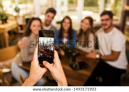 Taking a photo of a group of friends at the bar 