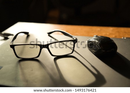 Eyeglasses and a computer mouse over a laptop computer. Royalty-Free Stock Photo #1493176421
