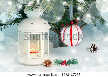Christmas composition - a lantern with a burning candle and decorations under the Christmas tree