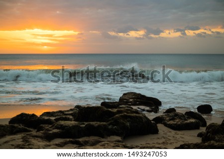 Beach at sunset. Seascape. Bright sunlight. Horizon line. Beach with rocks, stones, sand. Ocean with waves. Scenic view. Sunset time at the beach. Magnificent scenery. Tegal Wangi, Bali Indonesia