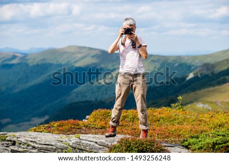 travel the world and take pictures, a man with a camera in the mountains