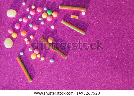 Colorful candy on purple background. Top view. Flat lay. Colorful sweets. Lollipops and candies. Top view with space for your greetings.
