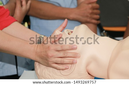 Demonstrating CPR (Cardiopulmonary resuscitation) training medical procedure on CPR doll in the class.Paramedic demonstrate first aid practice for save life.

