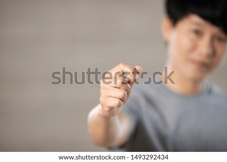Asian man wears gray shirt, showing gesture of stretch out his hand, concept for advertising.
