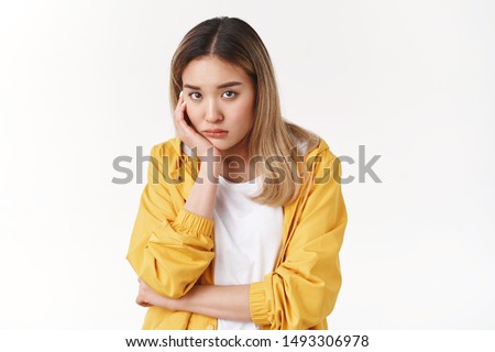 Gloomy young sad asian blond girl sighing upset stoop look from under forehead lonely unhappy lean palm bored feel regret sadness moody expression standing white background pessimistic Royalty-Free Stock Photo #1493306978
