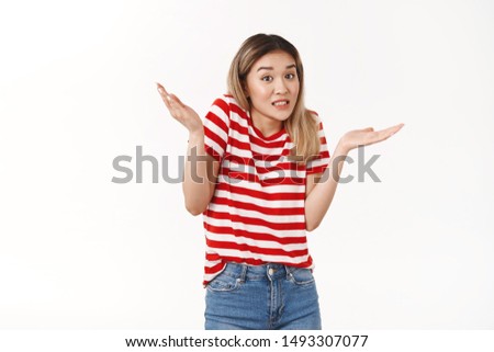 Yikes sorry my fault. Awkward silly timid blond asian girl new team member apologizing making mistake oops raise hands sideways clenching teeth stooping worried, standing confused white background Royalty-Free Stock Photo #1493307077