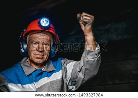 Miner man hands protest fist up revolution coal mine. Concept workers strike. Royalty-Free Stock Photo #1493327984