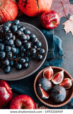 Autumn food flat lay with season fruits and vegetables like Bangalore blue grape, red apples and figs on a table. 