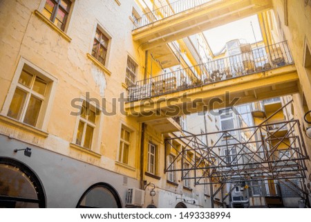 yellow courtyard of historical house with balconies and bridges
