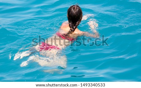 The girl swims in the water . Summer vacation at sea