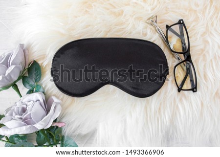 Blank black sleep mask on skin speep background with purple rose, pen and reading glasses, bridal sleep mask mockup