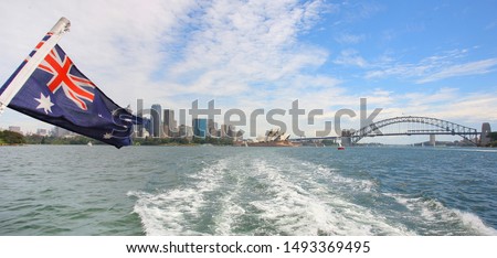 Panoramic shot of Sydney harbour with bridge, Sydney skyline and Australian flag waving on foreground