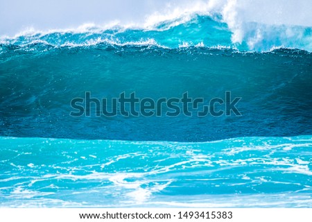 close up of beautiful and bigs blue and green waves breaking - pacific or athlantic ocean - blue sea and great place to surf - white spume on the photo