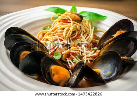 Steamed mussels in wine and garlic sauce with whole wheat pasta. Flat lay, above shot, close-up.