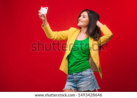 The girl takes a selfie on a mobile phone