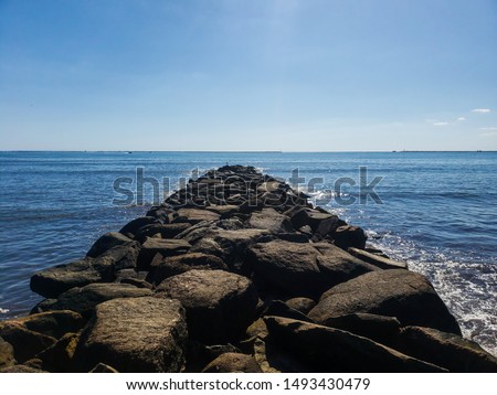 Narragansett, RI/USA - August 29, 2019. Photo taken on the beach of Narragansett showing a pile of rocks forming a bridge.