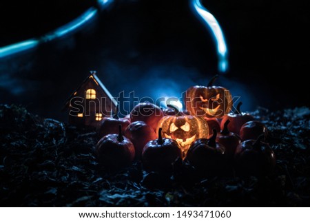 halloween jack-o-lantern on autumn leaves. Scary Halloween Pumpkin looking through the smoke. Glowing, smoking monster pumpkin from depths of hell