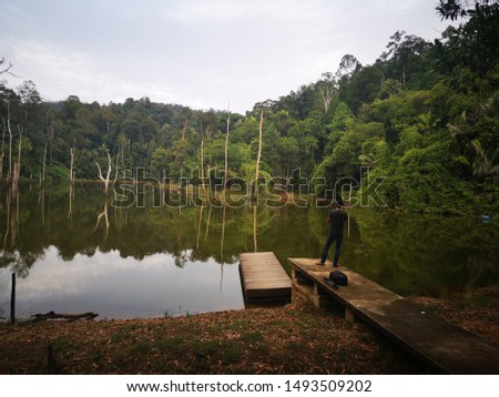 Nature photographer tourist with camera and wear a malay destar shoots Beautiful Nature UUM natural landscape. Sintok lake