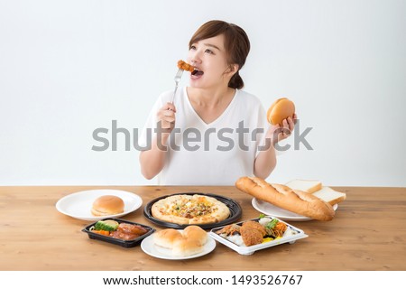The Asian woman who eats junkfood Royalty-Free Stock Photo #1493526767