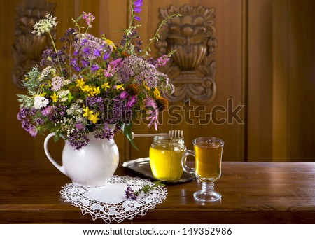 Still life from medicinal herbs, honey, herbal tea on a wooden background