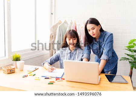 Entrepreneurs small business owner,Asian women Fashion designer drawing new sketches collection,sent a business e-mail to client.sales success,working using laptop,digital smartphone in workshop
